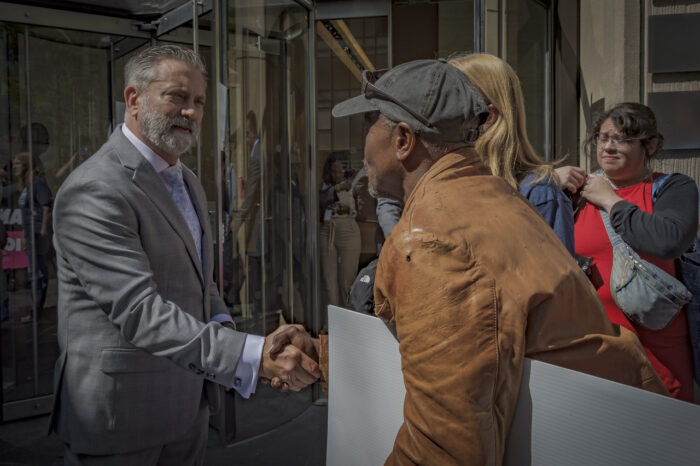 A representative outside Chubb in NYC shaking Manning's hand. 