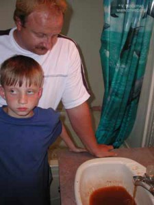Kenny Stroud and his son ponder their contaminated water in their Rawl, Mingo County, W.Va. home. Photo credit: Sludge Safety project