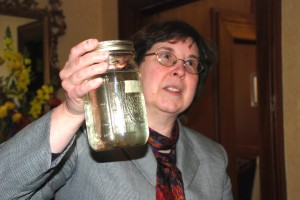 Bev May holds a jar of contaminated water