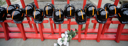 Mine helmets and painted crosses sit at the entrance to Massey Energy's Upper Big Branch coal mine Tuesday, April 5, 2011, one year after 29 miners were killed there.