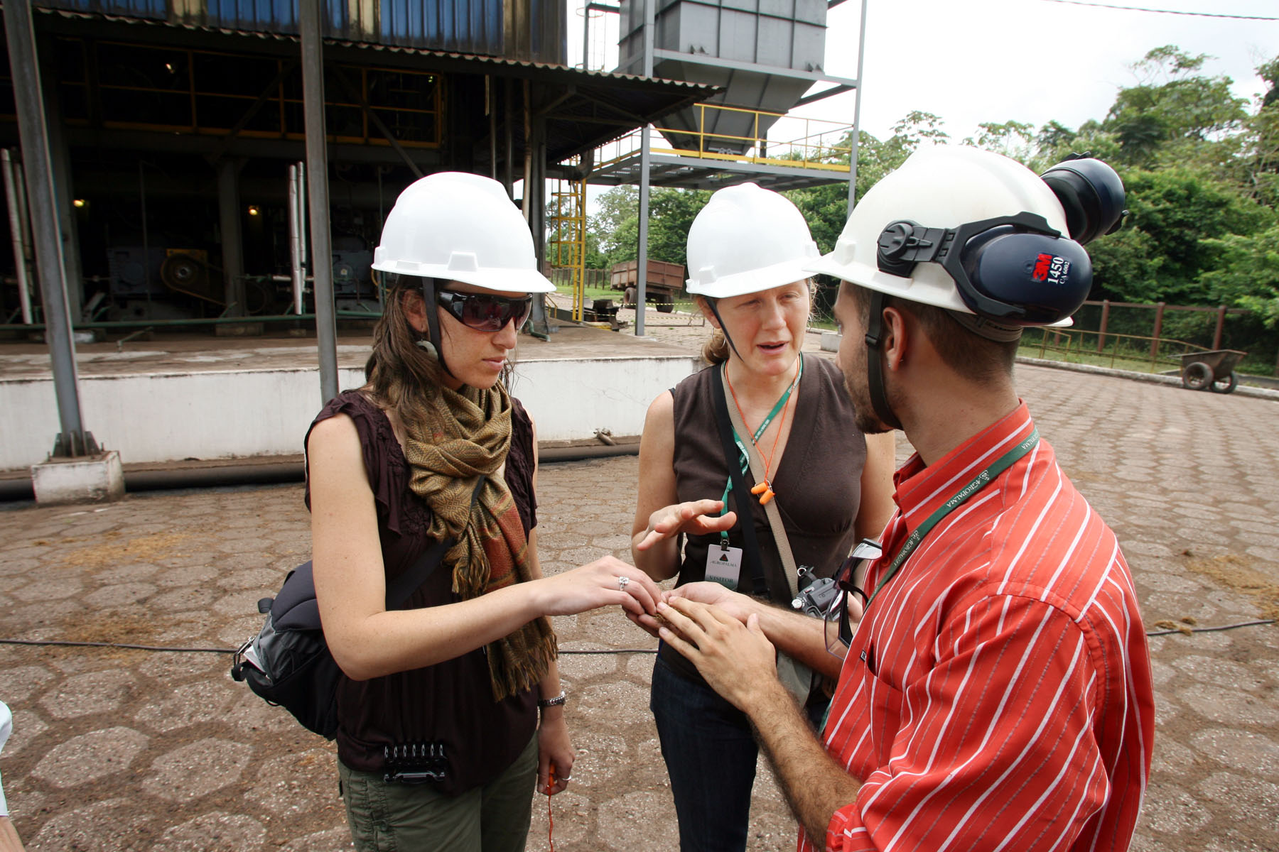 Andrea and Levana in front of the on-site oil palm processing facility